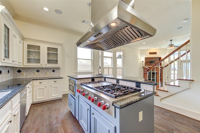 kitchen featuring appliances with stainless steel finishes, a center island, ornamental molding, and island range hood