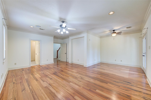 empty room with a ceiling fan, light wood-type flooring, visible vents, and crown molding