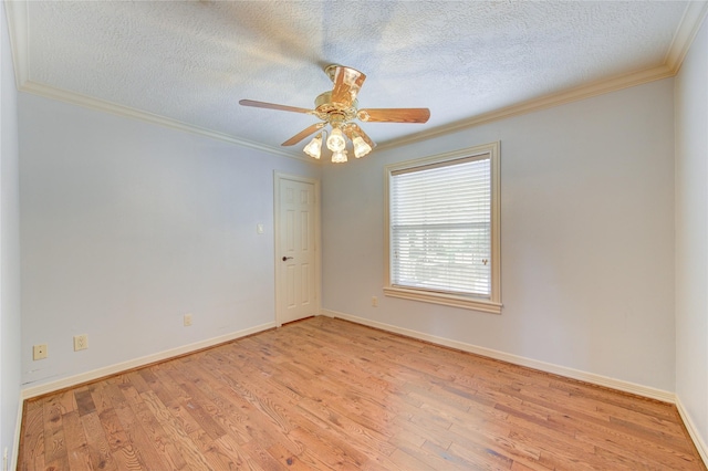 spare room featuring ornamental molding, light wood-type flooring, a textured ceiling, and baseboards