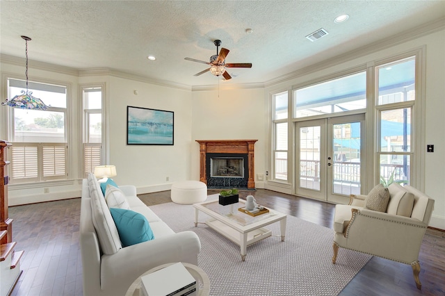 living area with visible vents, ornamental molding, dark wood finished floors, and french doors