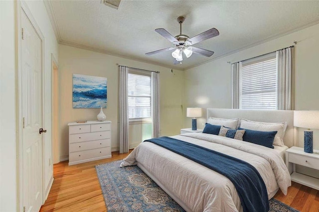122 Vieux Carre Dr, Houston, TX 77009 - bedroom with light wood finished floors, crown molding, a ceiling fan, and baseboards