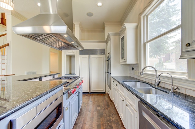 122 Vieux Carre Dr, Houston, TX 77009 - kitchen with island range hood, a sink, stainless steel appliances, ornamental molding, and white cabinetry