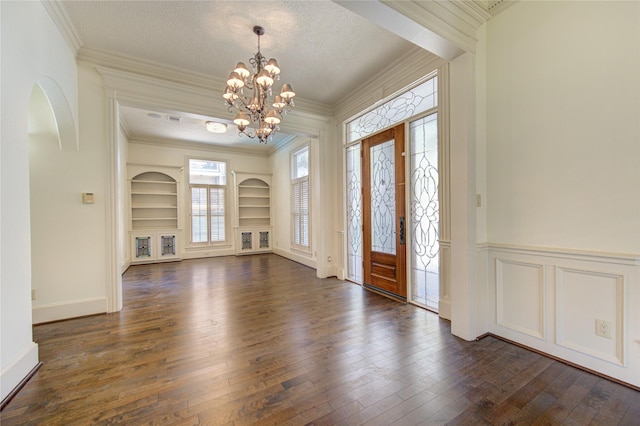 122 Vieux Carre Dr, Houston, TX 77009 - foyer featuring dark wood finished floors, a chandelier, ornamental molding, and arched walkways