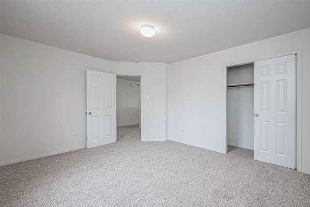 unfurnished bedroom with a closet, carpet flooring, and baseboards