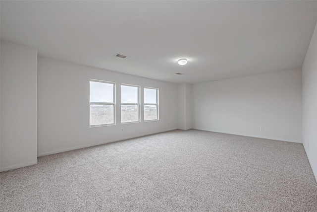 unfurnished room featuring light carpet, visible vents, and baseboards