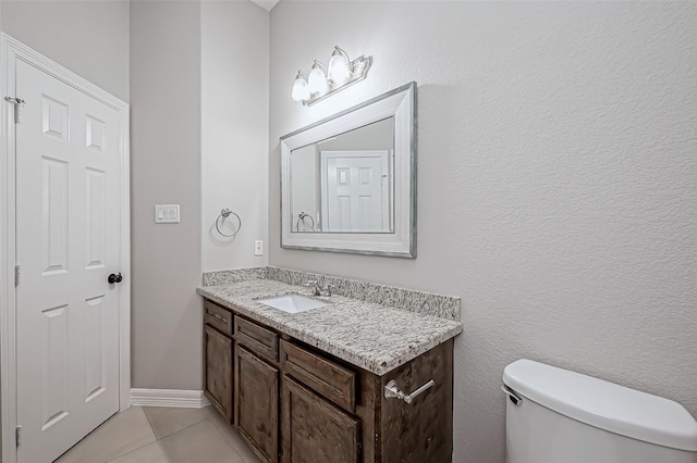 bathroom featuring tile patterned flooring, baseboards, vanity, and toilet