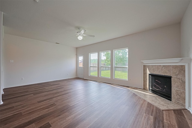 9514 Barr Spring Dr, Humble, TX 77396 - unfurnished living room with a ceiling fan, dark wood-type flooring, and a tile fireplace