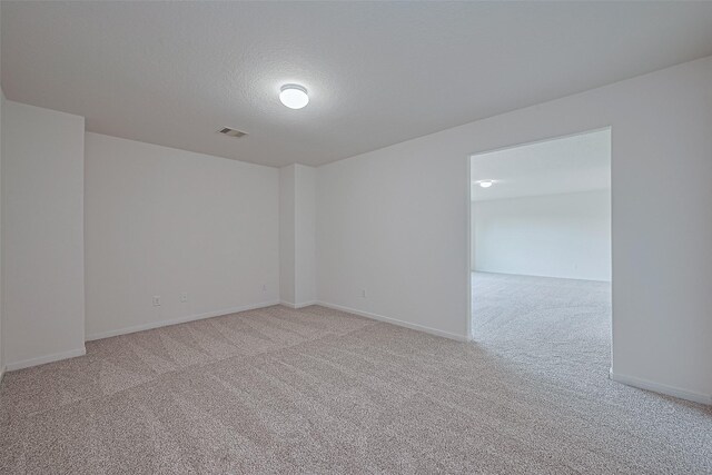 9514 Barr Spring Dr, Humble, TX 77396 - empty room featuring light colored carpet and a textured ceiling
