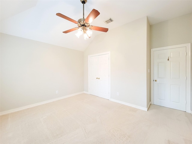 unfurnished bedroom with baseboards, light carpet, lofted ceiling, and visible vents