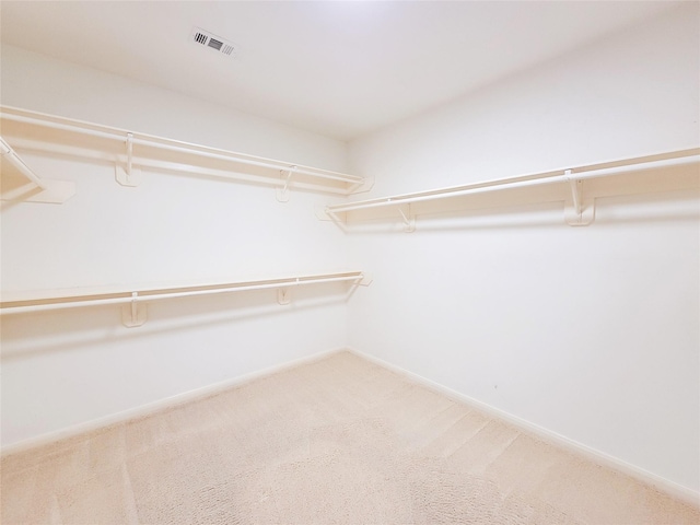 walk in closet featuring light colored carpet and visible vents
