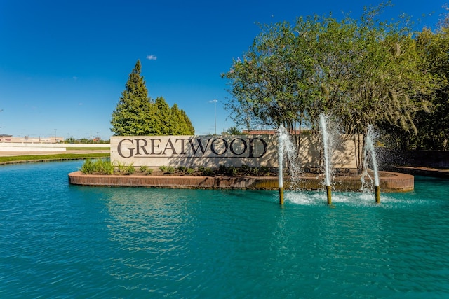 community / neighborhood sign with a water view