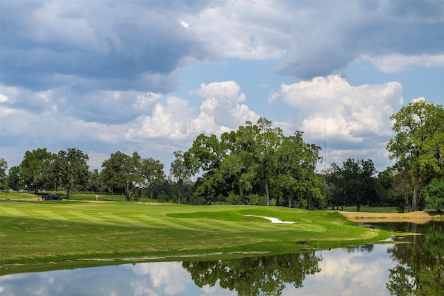 view of property's community with a water view, golf course view, and a yard