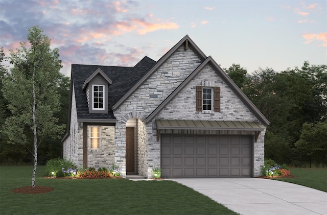 french provincial home featuring a garage, a lawn, concrete driveway, and brick siding