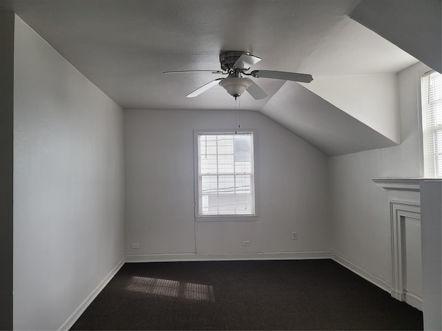 additional living space featuring lofted ceiling, a ceiling fan, a wealth of natural light, and baseboards