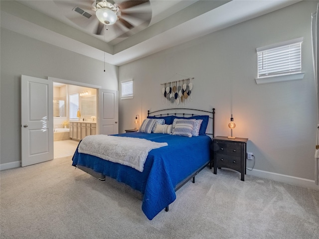 bedroom with baseboards, a tray ceiling, and carpet flooring