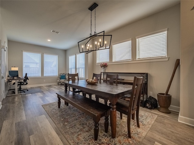 dining room with baseboards, visible vents, and wood finished floors