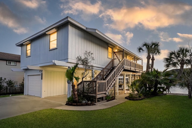 exterior space with a garage, driveway, stairs, and a yard