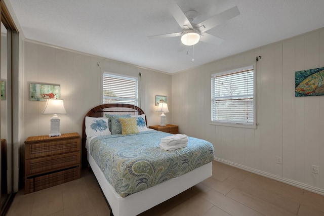 bedroom with ceiling fan and baseboards