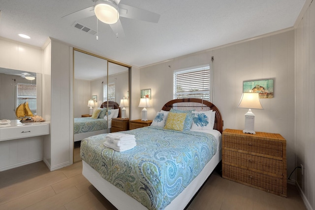 bedroom with a closet, visible vents, crown molding, and ceiling fan