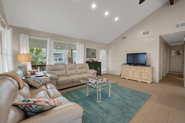 living area featuring light tile patterned floors, visible vents, and high vaulted ceiling