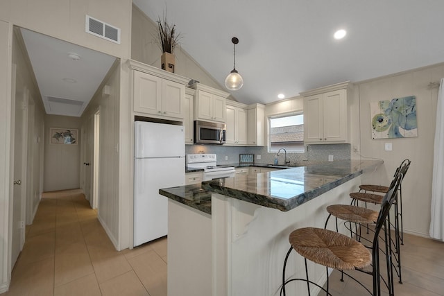 kitchen with white appliances, light tile patterned floors, visible vents, decorative light fixtures, and a peninsula