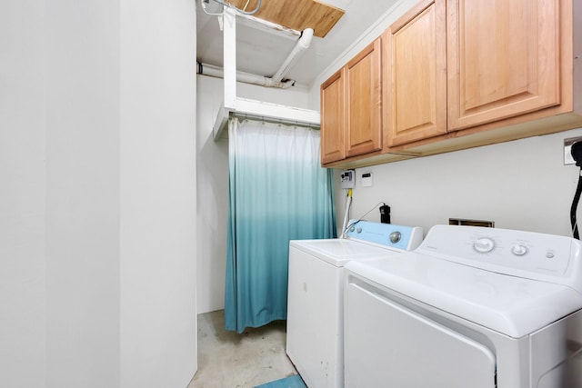 washroom featuring cabinet space and washer and clothes dryer