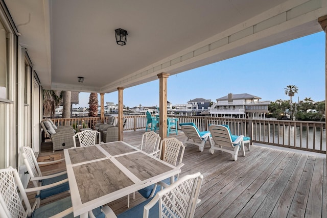 wooden deck with outdoor dining space and a water view