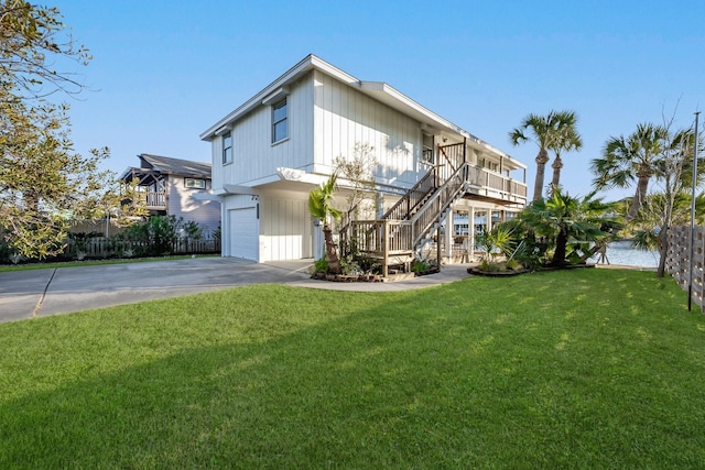 exterior space featuring driveway, a garage, stairway, and a lawn