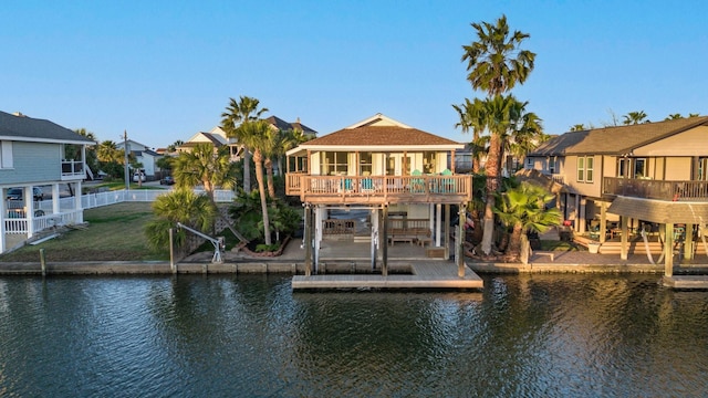 exterior space with a water view, a residential view, fence, and a yard