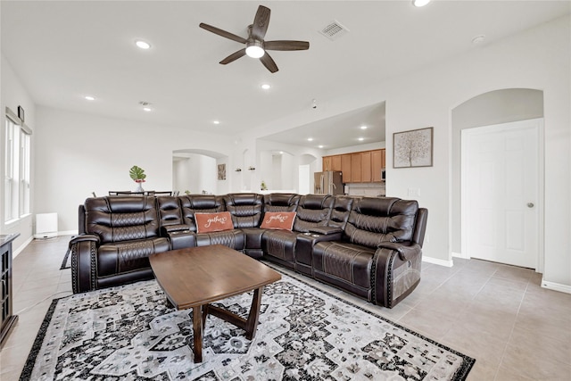 living area featuring arched walkways, light tile patterned floors, recessed lighting, visible vents, and baseboards