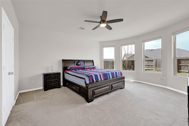 bedroom with baseboards, ceiling fan, visible vents, and light colored carpet