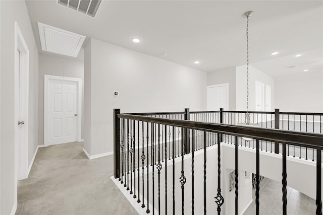 corridor featuring recessed lighting, light carpet, visible vents, baseboards, and attic access