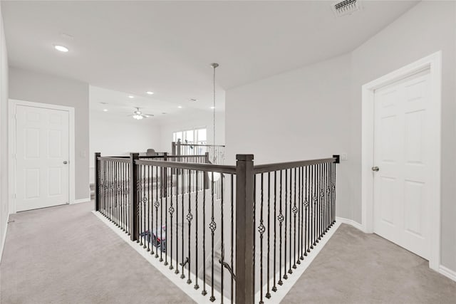 hallway featuring recessed lighting, light carpet, visible vents, and baseboards