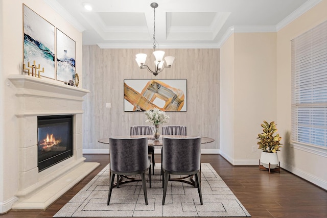 dining room with baseboards, coffered ceiling, a glass covered fireplace, wood finished floors, and a notable chandelier