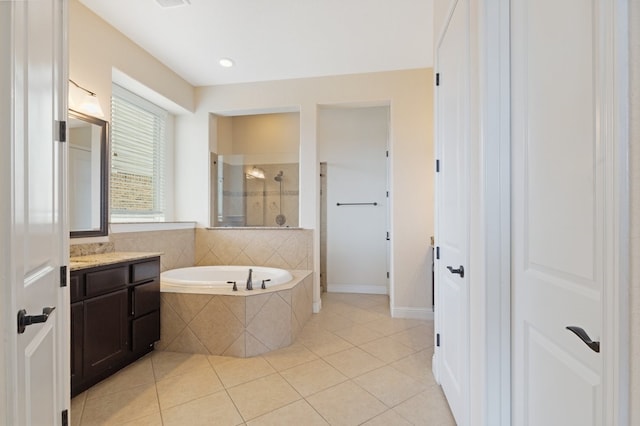 bathroom with vanity, tile patterned flooring, a tile shower, and a bath