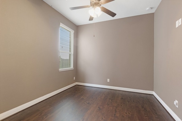 unfurnished room featuring dark wood-style flooring, ceiling fan, and baseboards