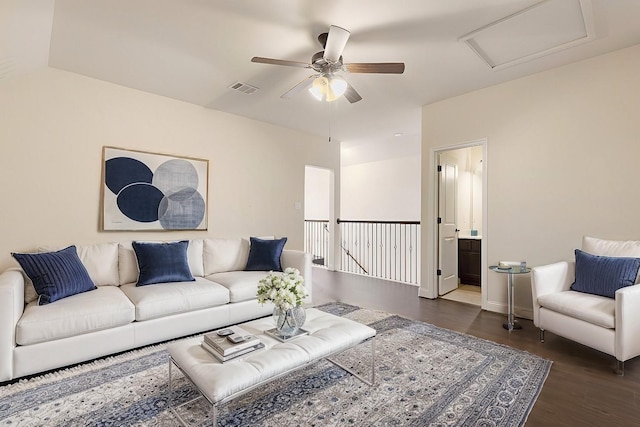 living area featuring attic access, visible vents, ceiling fan, and wood finished floors