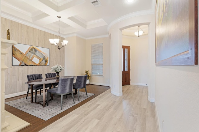 dining space with wood finished floors, visible vents, and crown molding