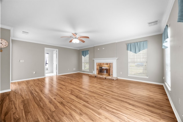 unfurnished living room featuring light wood-style flooring, a brick fireplace, visible vents, and baseboards