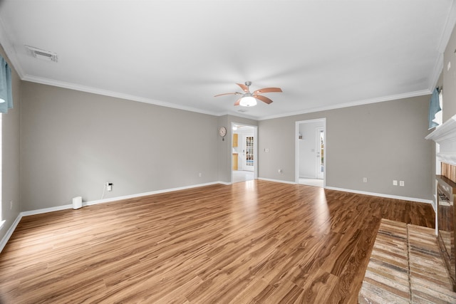 unfurnished living room featuring ornamental molding, a fireplace, wood finished floors, and visible vents