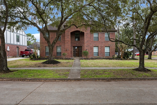 view of front of home with a front lawn and brick siding