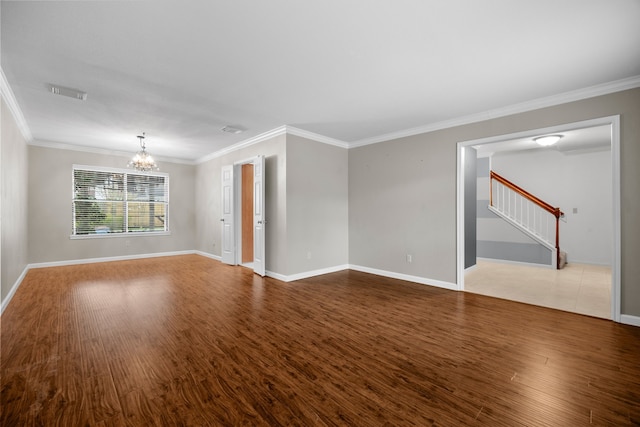 unfurnished room with crown molding, a chandelier, and wood finished floors