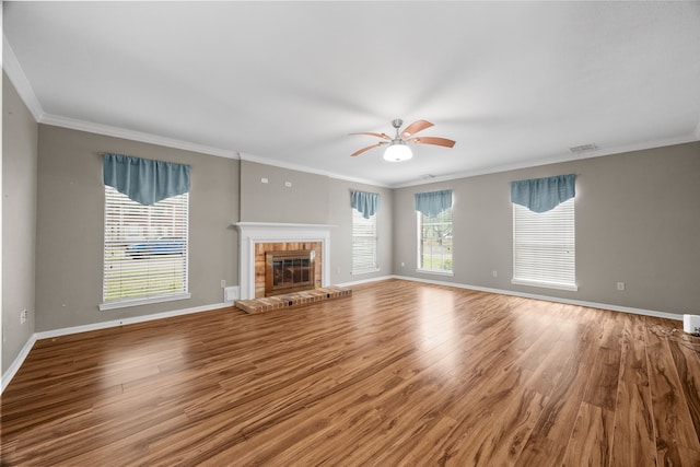 unfurnished living room with crown molding, a fireplace, baseboards, and wood finished floors