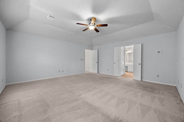 unfurnished bedroom with a textured ceiling, carpet floors, visible vents, and baseboards