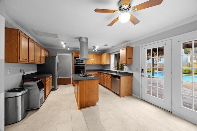 kitchen with dark countertops, appliances with stainless steel finishes, ornamental molding, a center island, and a sink