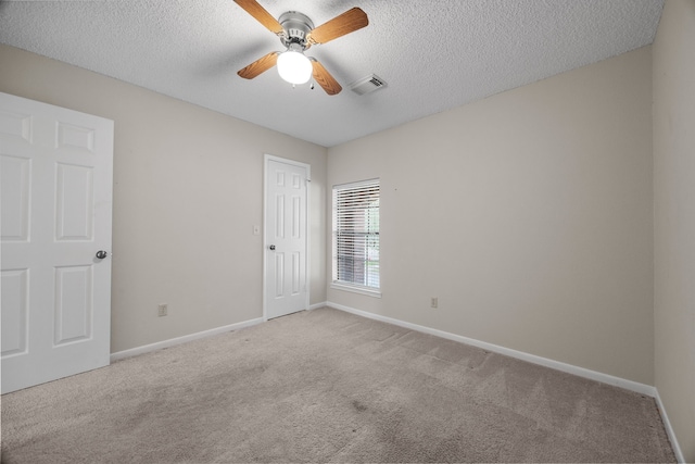 carpeted spare room with a textured ceiling, ceiling fan, and baseboards