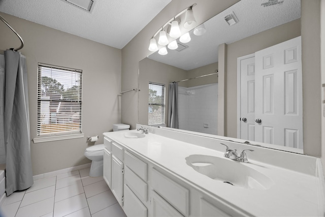 bathroom with a textured ceiling, a sink, toilet, and tile patterned floors