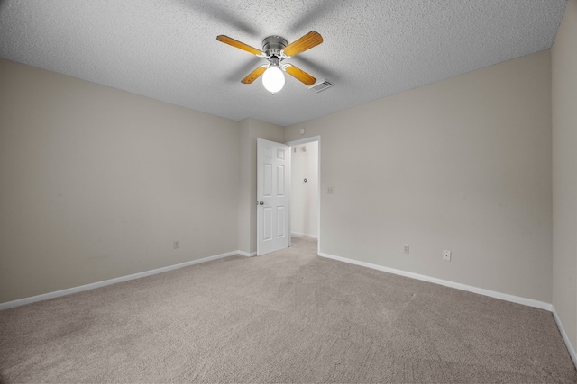 carpeted spare room featuring baseboards, visible vents, ceiling fan, and a textured ceiling