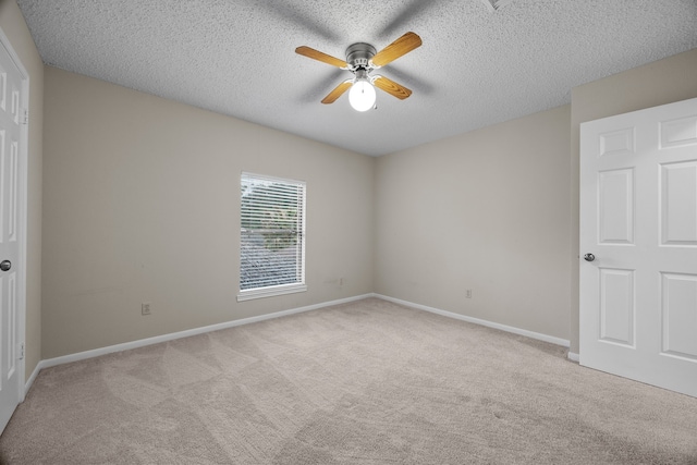 unfurnished room featuring carpet, ceiling fan, a textured ceiling, and baseboards