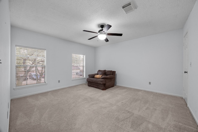 unfurnished room featuring baseboards, visible vents, a ceiling fan, a textured ceiling, and carpet flooring